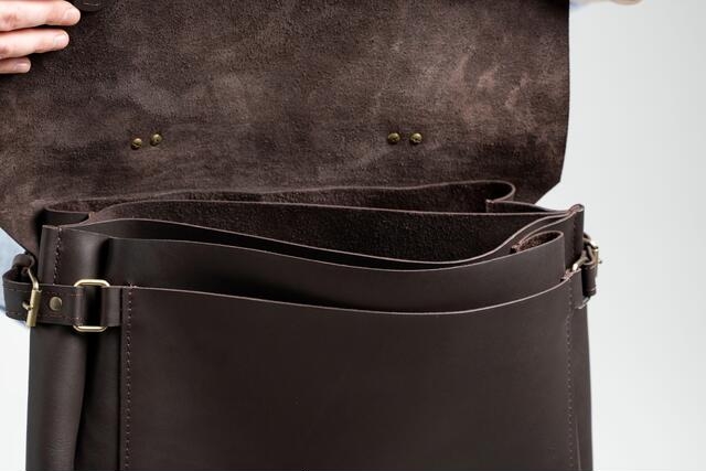 Sleek black leather messenger bag with adjustable shoulder strap and spacious interior.